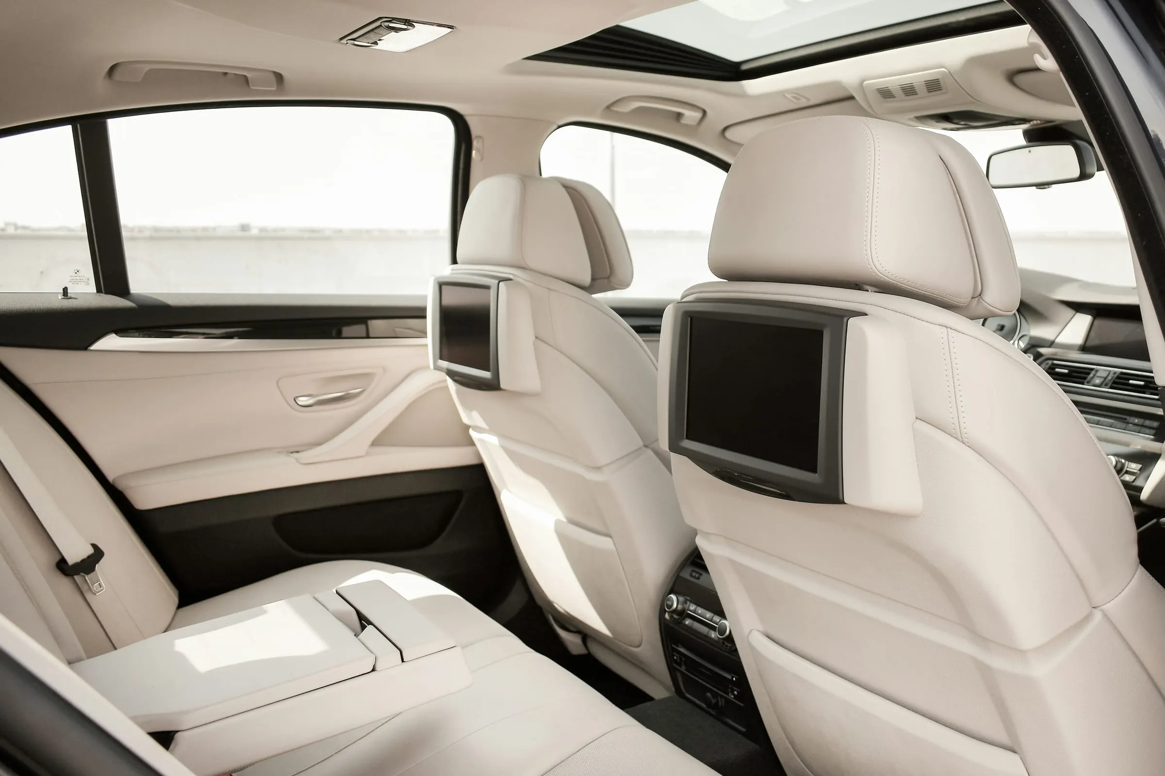 Cream leather rear car seats with headrest screens